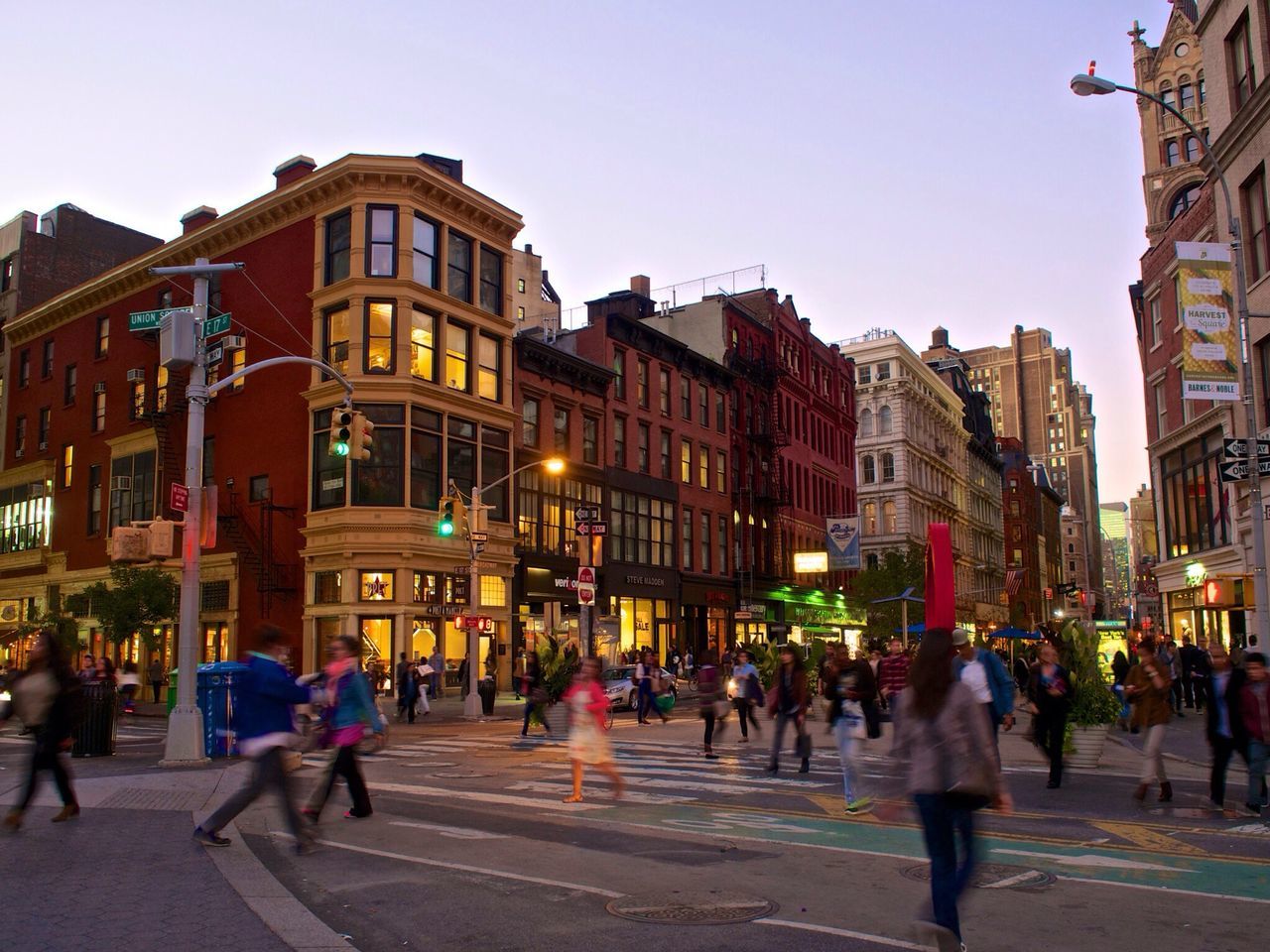 building exterior, architecture, built structure, large group of people, street, city, person, city life, walking, men, lifestyles, city street, illuminated, clear sky, sky, street light, travel destinations, leisure activity, outdoors