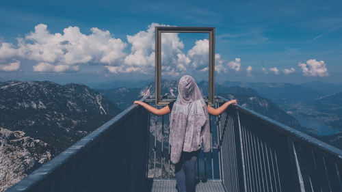 Woman standing on mountain against sky