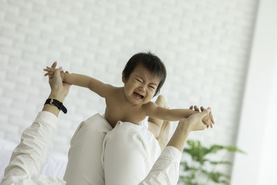 Low section of mother playing with crying daughter