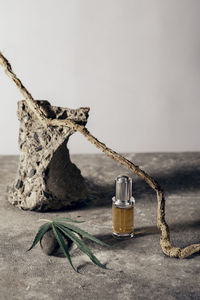 Glass bottle with cbd oil, thc tincture, hemp leaf on gray marble background. naturalness. cbd oil