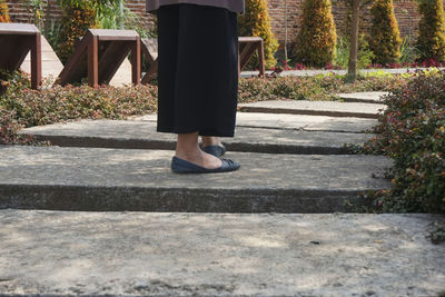 Low section of woman walking on footpath