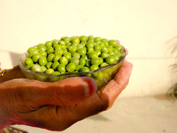 Close-up of hand holding green peas