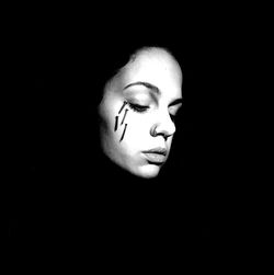 Close-up portrait of young woman against black background