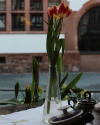 Close-up of flower vase on table by window