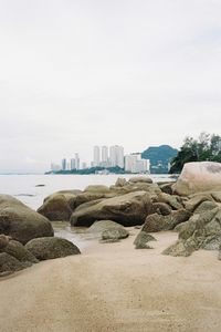 Scenic view of beach by city against sky