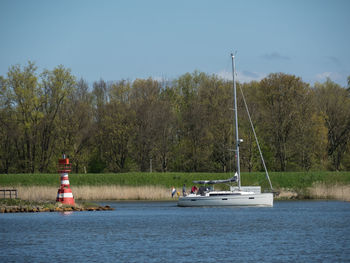 Sailboat sailing on sea against sky