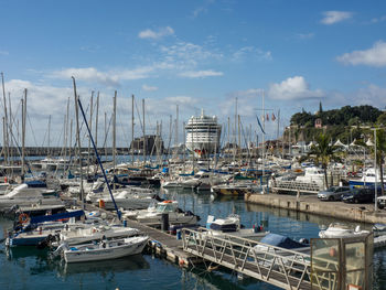 Sailboats moored in harbor