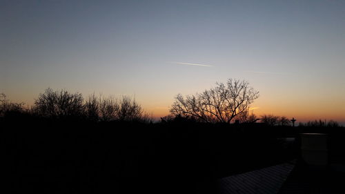 Silhouette trees against sky at sunset