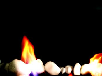 Close-up of illuminated candles against black background