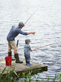 Father with son fishing on jetty