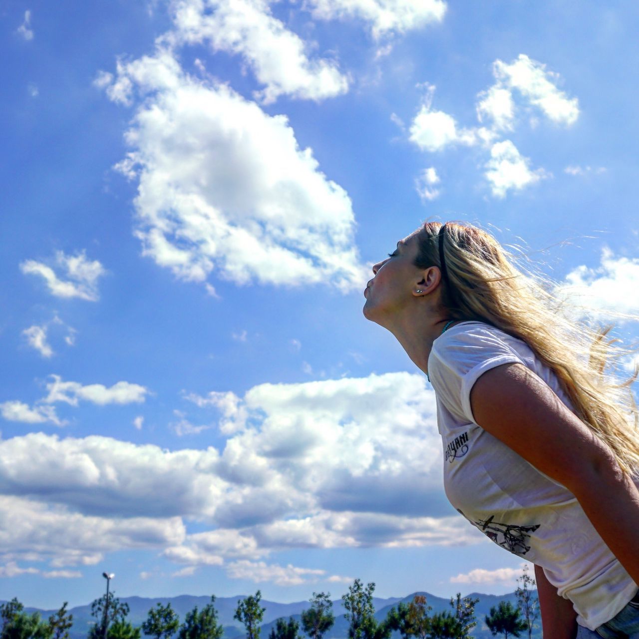 sky, cloud - sky, one person, low angle view, day, young women, young adult, standing, leisure activity, side view, real people, outdoors, nature, women, tree, beautiful woman, blond hair, beauty in nature, people