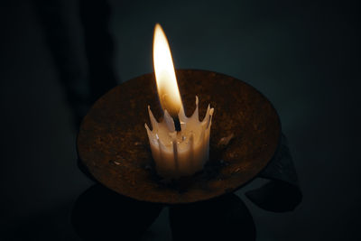 Close-up of illuminated candle against black background