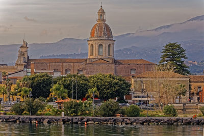 View of building by river against sky