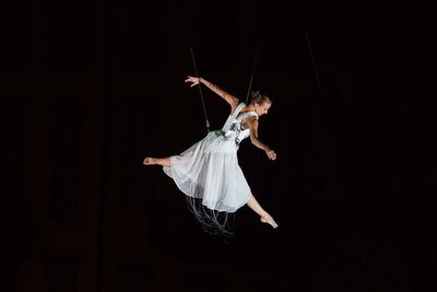 Woman dancing against black background