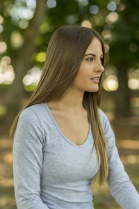 Thoughtful beautiful woman with long blond hair at park