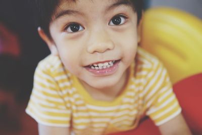 Close-up portrait of smiling boy at home