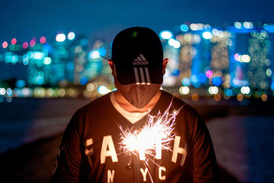 Portrait of man in illuminated city at night