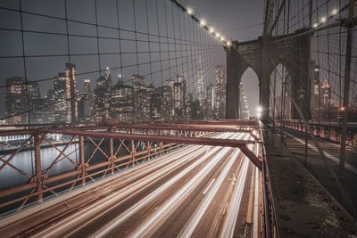 Light trails on bridge in city at night
