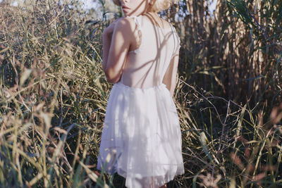 Midsection of woman standing amidst plants