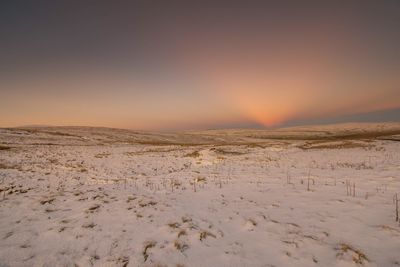 Scenic view of desert against sky during sunset