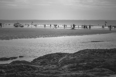 People at beach against sky