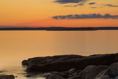 Scenic view of sea against orange sky