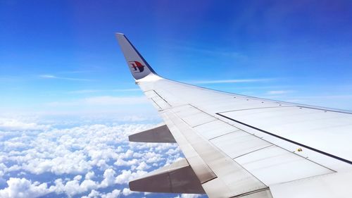 Cropped image of airplane flying over blue sky