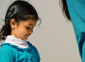 Girl standing by mother