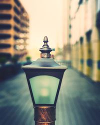 Close-up of illuminated lantern on street against sky