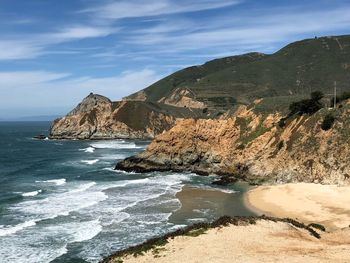 Scenic view of sea and mountains against sky