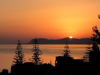 Scenic view of silhouette mountains against orange sky