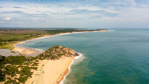 Tropical landscape with a beautiful beach in the blue water. crocodile rock, sri lanka.