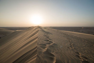 Scenic view of desert against sky during sunset