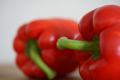 Close-up of red chili peppers over white background
