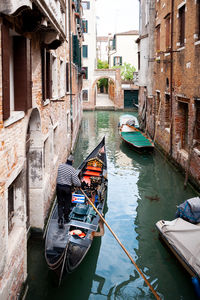 Narrow canal with gondola in cannaregio ghetto in venice