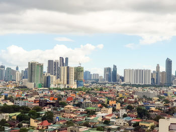 Aerial view of buildings in city against sky