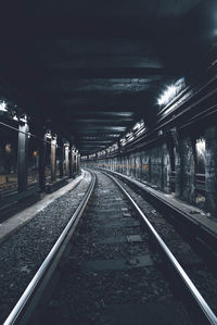 Railroad tracks in illuminated tunnel