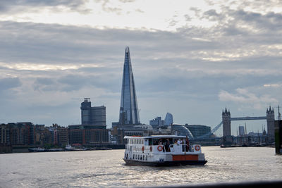 Nautical vessel on sea against buildings in city