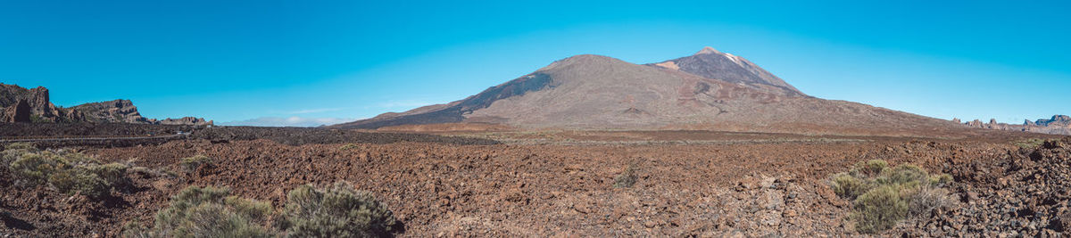 Scenic view of mountain range against blue sky