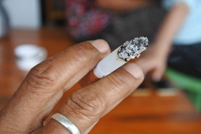 Close-up of hand holding cigarette