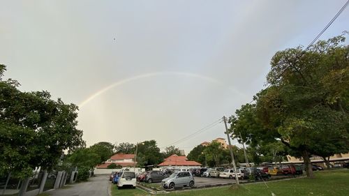 Rainbow over city against sky