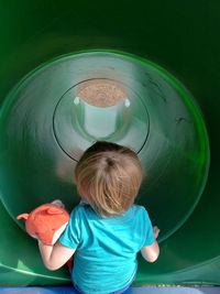 Rear view of boy playing in tunnel slide