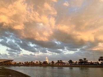 River by buildings against sky at sunset