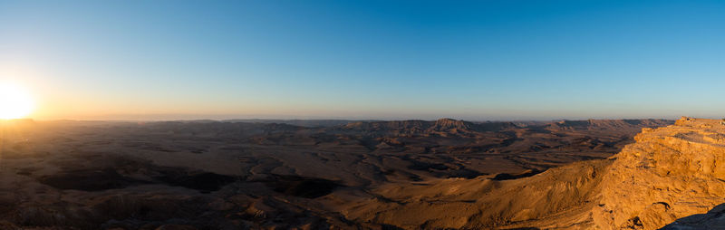 Scenic view of dramatic landscape against clear sky during sunset