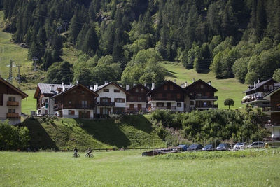 Panoramic shot of trees and houses on field against buildings