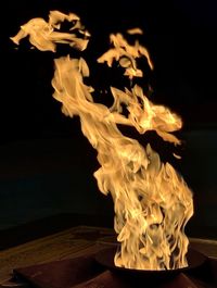 Close-up of fire on table against black background