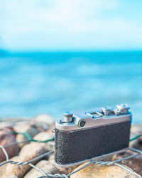 Close-up of machine part on beach against sky