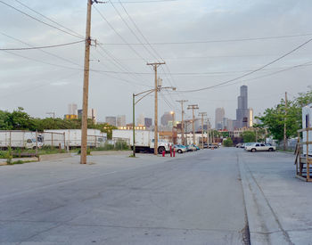 Cars on road against sky in city