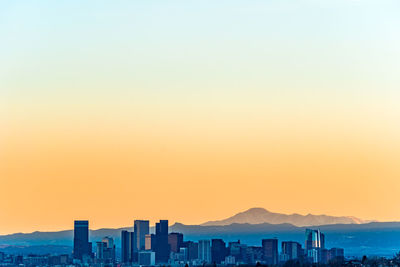 View of buildings against clear sky at sunset