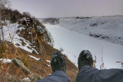 Low section of person on snowcapped mountains during winter